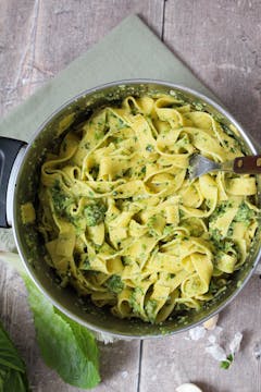 mixed lettuce pesto and pasta in a pot