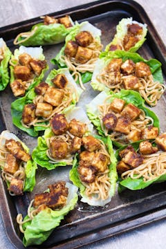 13 assembled lettuce wraps all on a baking tray. 