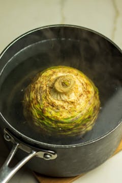 celeriac boiling in a black pan