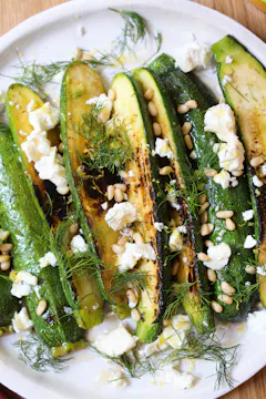 baby courgettes with feta on a white plate