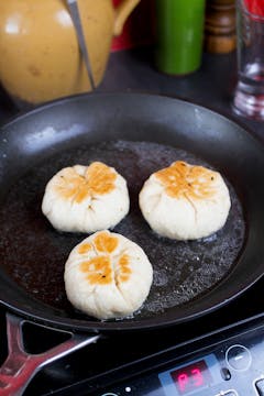 buns being fried in a pan