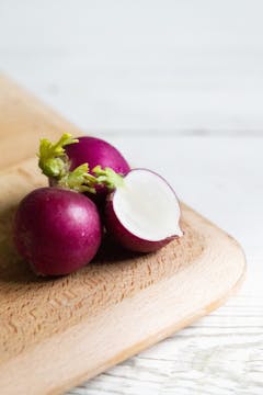 3 radishes on a chopping board