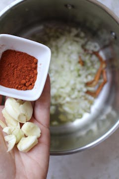 paprika and garlic being added to the sauce pan
