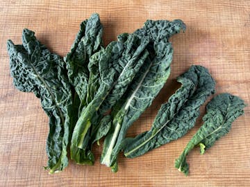 cavolo nero leaves on a wooden table 