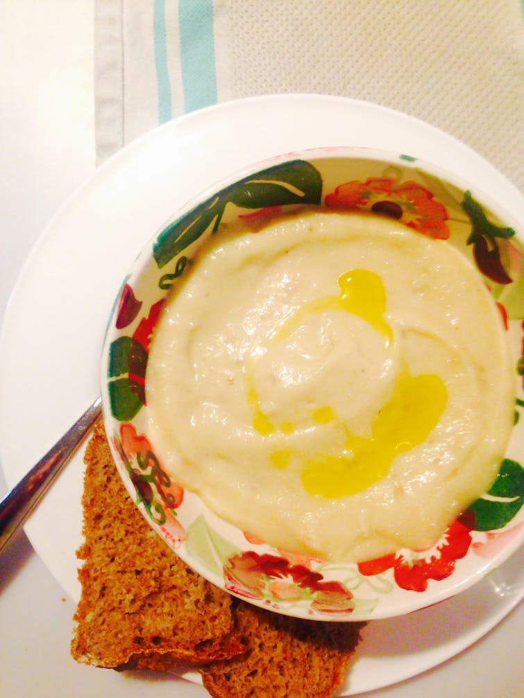 A bowl of creamy parsley root soup. Served with bread.