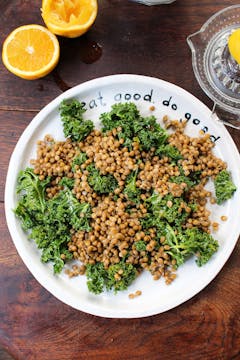 kale leaves topped with lentils on a white plate