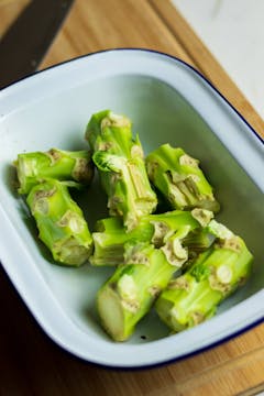 A pile of broccoli stalks in a bowl.