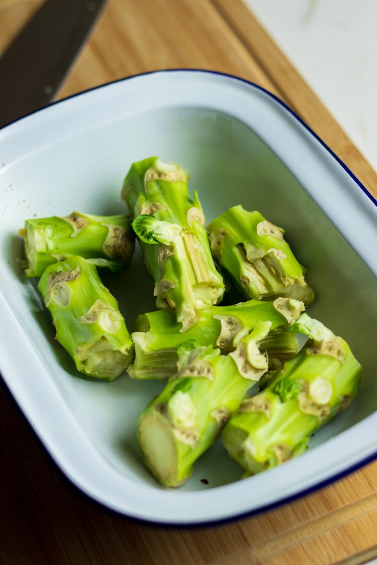 A pile of broccoli stalks in a bowl. 