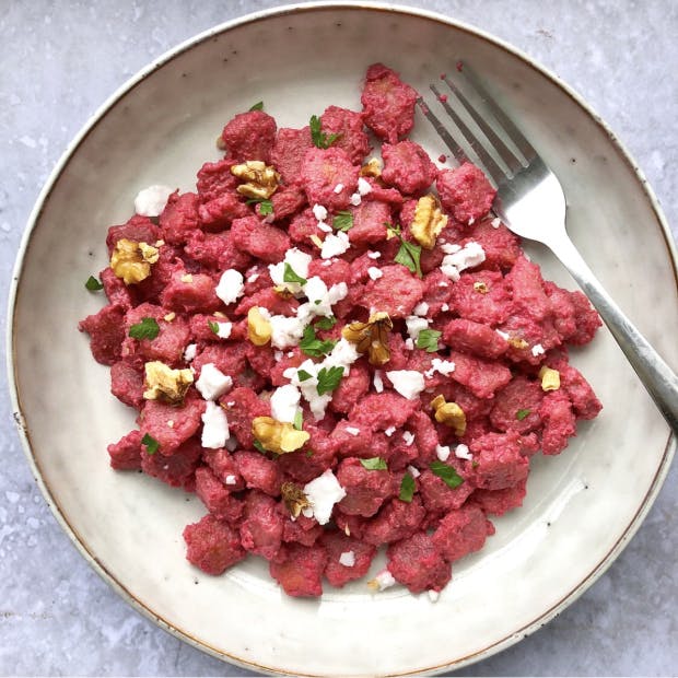 Cauliflower gnocchi covered in a beetroot pasta sauce, garnished with quark and parsley.