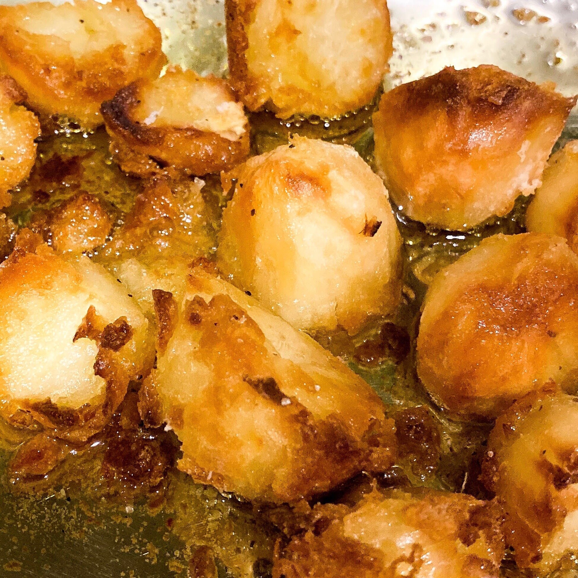Golden brown roasted potatoes in a tray