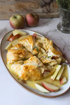 apple and brie tart on a white plate.
