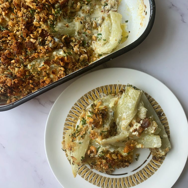 A serving of Fennel, Ricotta & Parmesan Gratin next to the full pan. 