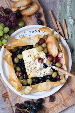 baked Feta with grapes on a plate with baking sheet