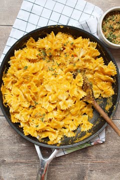 carrot sauce mixed with the pasta in a pan