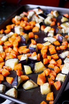 aubergine and carrots on a baking tray 