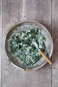 Wilted spinach mixed in a bowl with ricotta. 