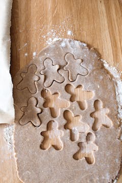 gingerbread men being cut out of cookie dough 