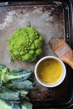 oven tray with romanesco and bowl of seasoned olive oil