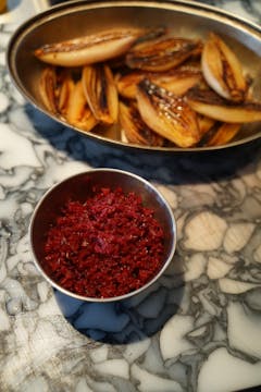 The bowl of shallots with a bowl of ruby red sauerkraut.