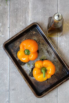 2 orange bell peppers on a oven dish