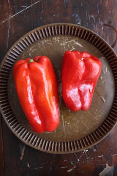2 red bell peppers on a baking tray