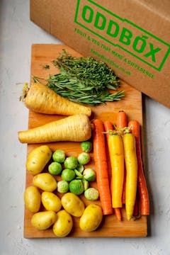 The contents of a Christmas Oddbox, with sage, rosemary, thyme, parsnips, carrots, potatoes, and brussel sprouts. 