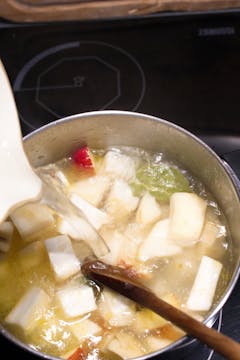 celeriac and apple in saucepan with stock