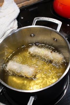 rolls cooking in vegetable oil in saucepan 