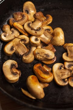 sliced mushroom in pan being fried 