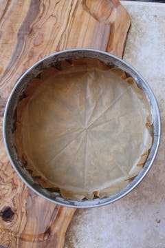 A cake tin with baking paper inside, the sides greased.