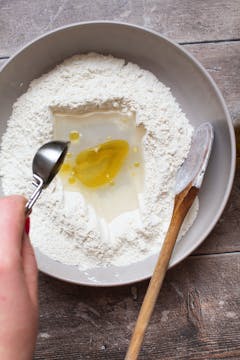 in a bowl, flour, olive oil and water 