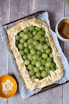 ready to bake gooseberry galette decorated with flaked almonds