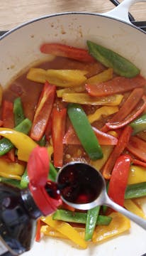 sliced peppers in a frying pan 