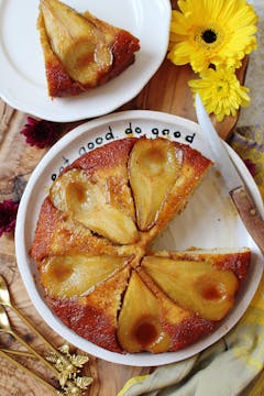 An upside down pear cake on a plate. There's a single serving that has been put onto a different plate above.