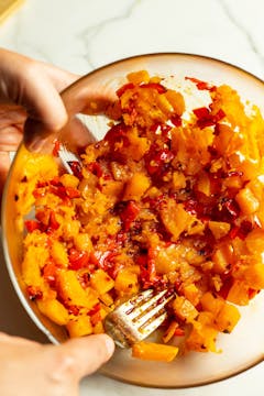 Squash and peppers being mashed after roasting.