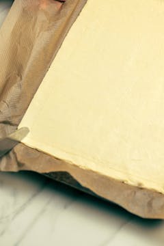 Puff pastry rolled across a baking tray, with a knife scoring a border around it.