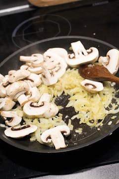 mushrooms and onion in frying pan 