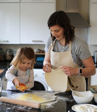 little girl and mum making pizza together