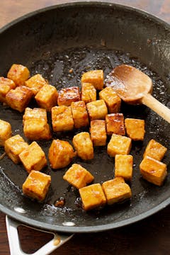 tofu being tossed in a char siu sauce