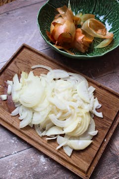 finely chopped onion on a wooden chopping board