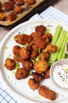 A plate of buffalo mushrooms, served with celery sticks and a bowl of vegan creme fraiche. 