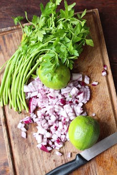 onion and herbs on chopping board 