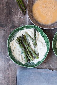Asparagus spears in a bowl of flour. 