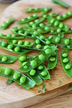 open pea pods on a chopping board