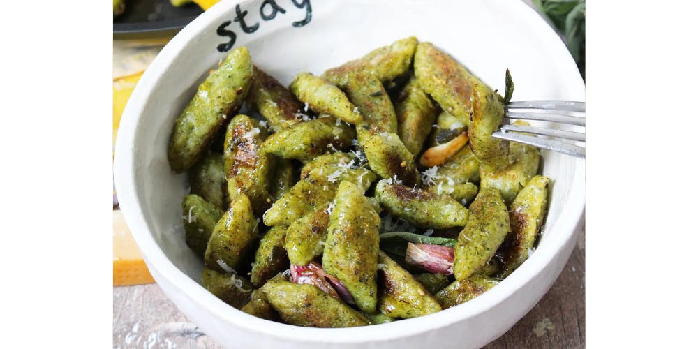 broccoli gnocchi in a white bowl 