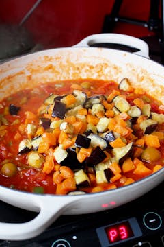 carrot caponata simmering in a pan