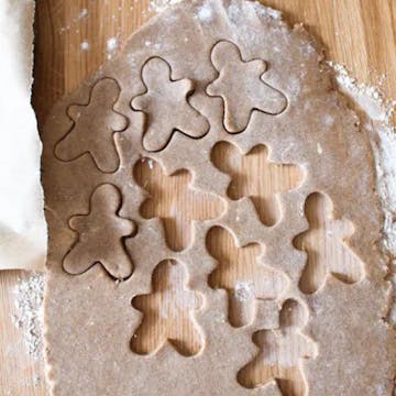 gingerbread dough rolled out with gingerbread men cut out of it