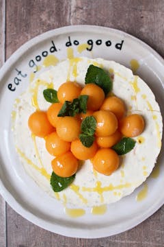 decorated cheesecake with melon balls and mint leaves 