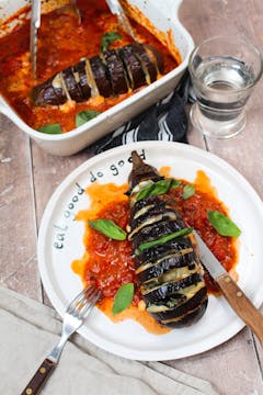 served hasselback aubergine parmigiana on a plate with cutlery