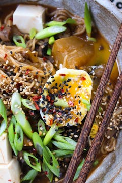 Zero-waste mushroom, ginger & garlic ramen in a white bowl with chopsticks